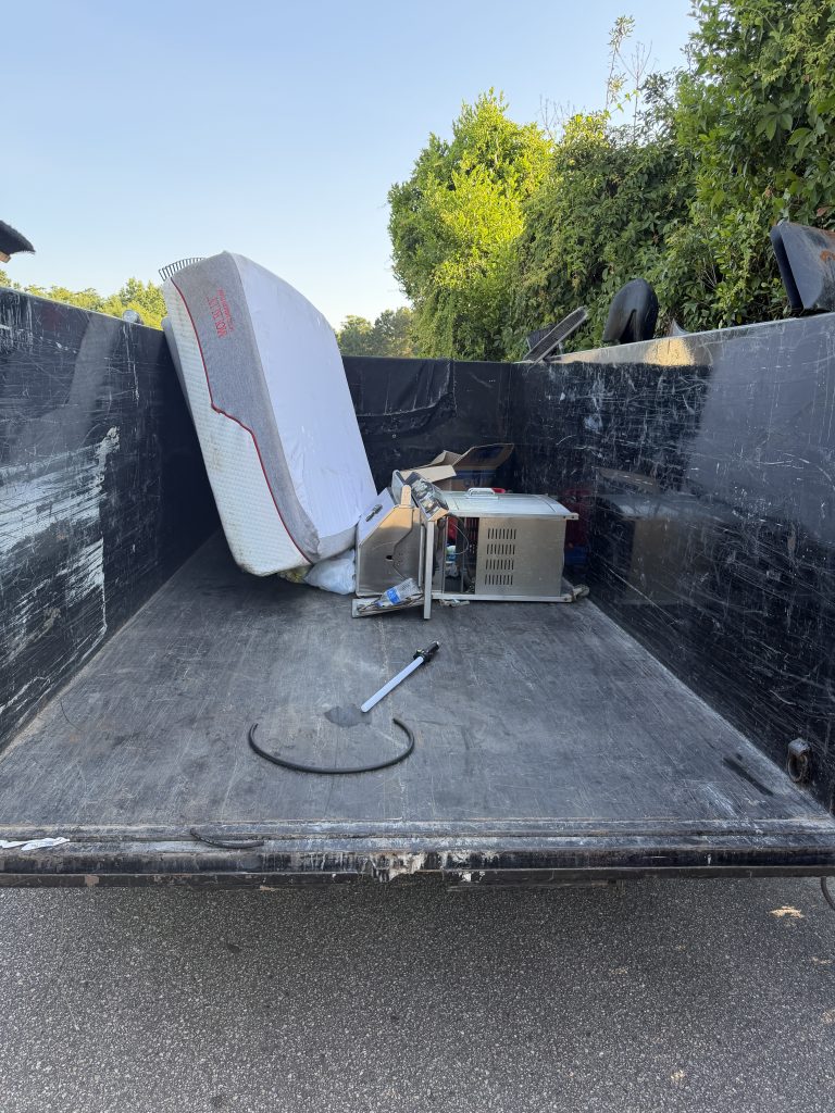 Old mattress and appliance loaded in a Hoard Haulers trailer